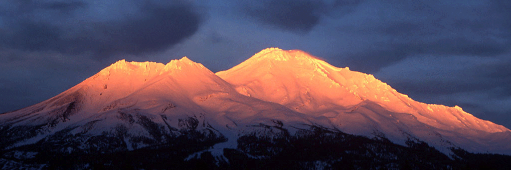 glowing mountain range with a deep blue sky behind it