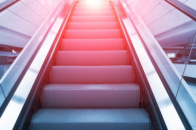escalator stairs with sunset light filtering down from top